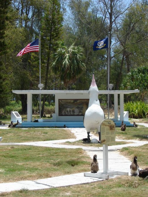 Bild: gehisste US-Flagge am Marinedenkmal (Navy Memorial) und Albatross-Statue auf der Sand-Insel